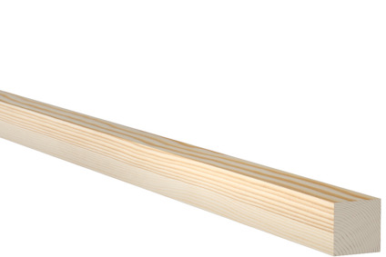 Planhyvlad träregel av furu mot svart bakgrund.