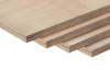 Flera lager av björkplywood staplade ovanpå varandra mot en svart bakgrund.