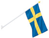 Svensk flagga på vit fasadstång med gult fäste.